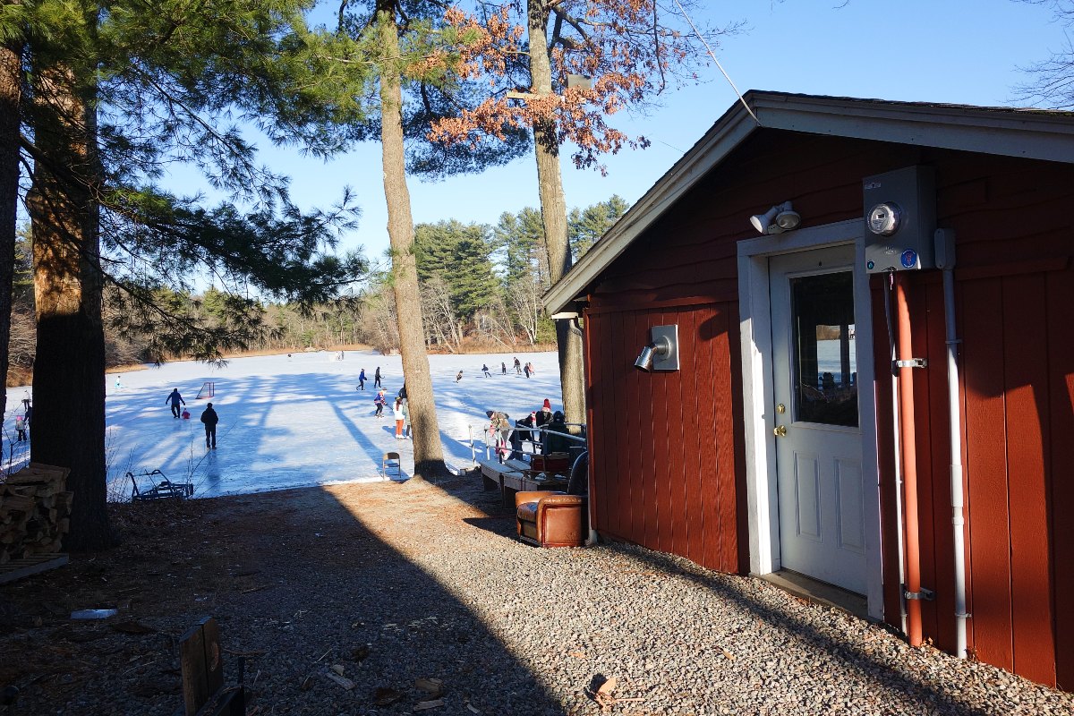 Side of lodge and view of ice skating pond at Turner Lodge and Pond in Walpole, Massachusetts.