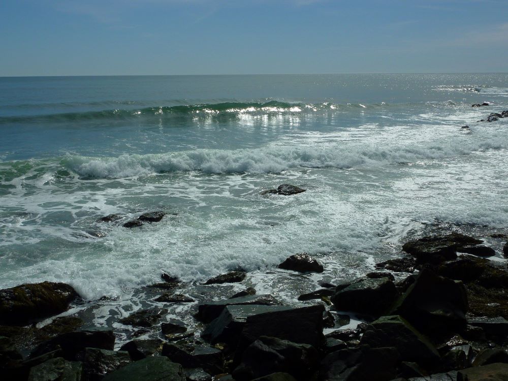 Waves shining light at the ocean by the Cliff Walk in Newport, Rhode Island.