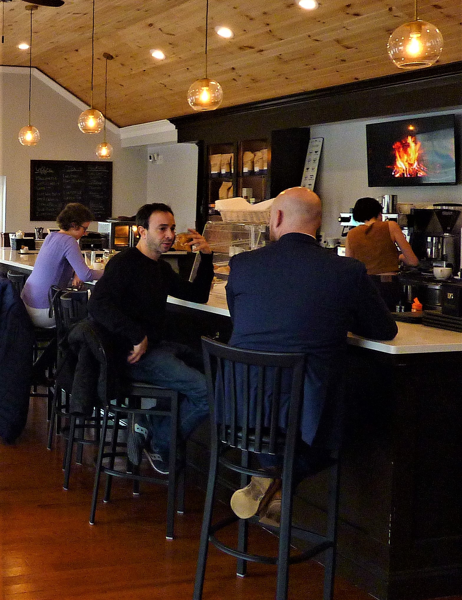 Alan Sky, owner of Millis Clicquot Coffee talks with a customer at the bar.