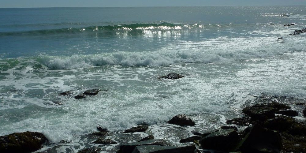 Waves shining light at the ocean by the Cliff Walk in Newport, Rhode Island.