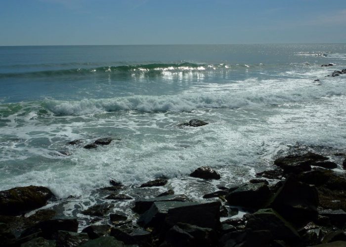 Waves shining light at the ocean by the Cliff Walk in Newport, Rhode Island.
